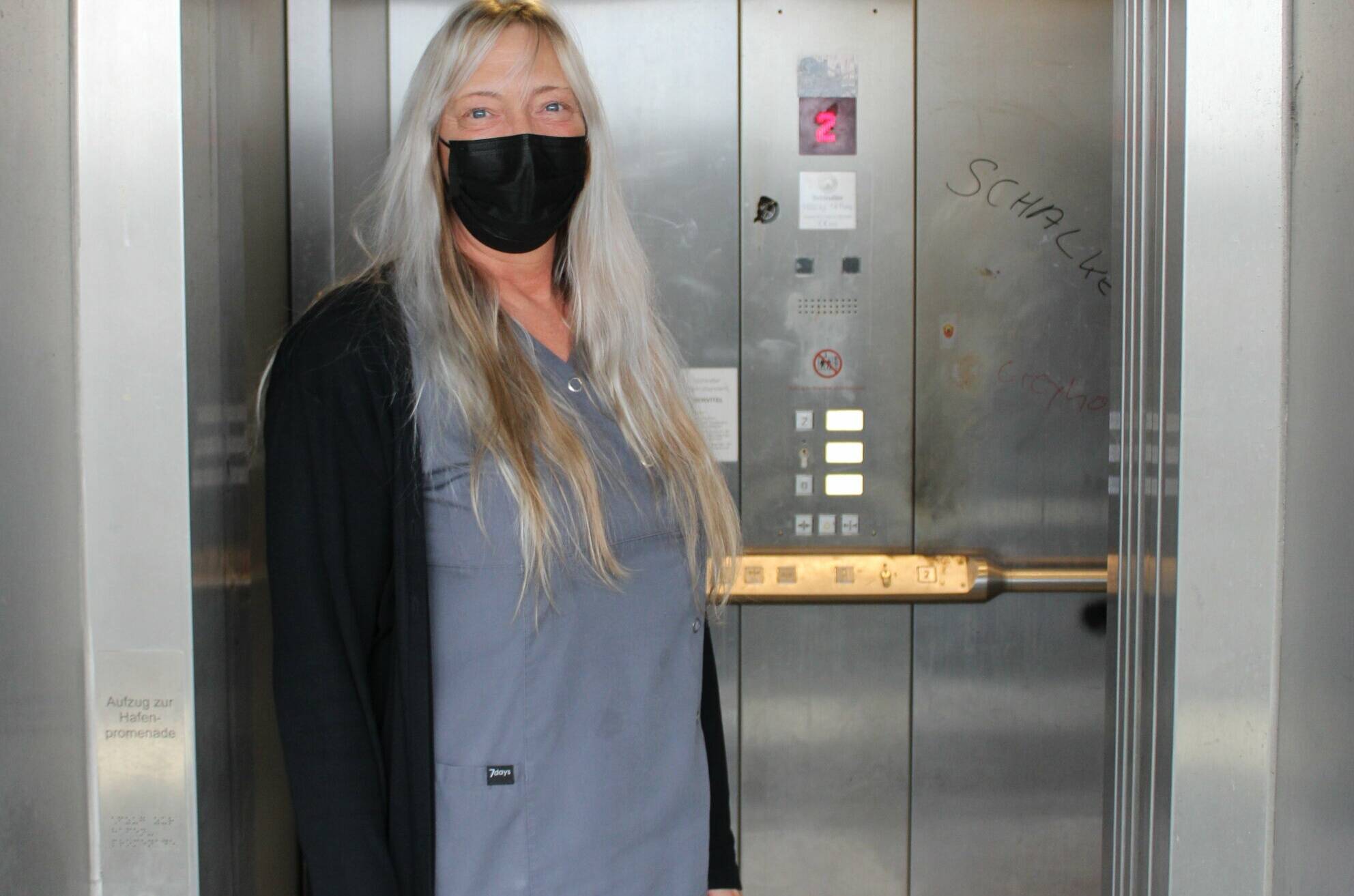   Da ist eine Maske wirklich empfehlenswert: Edith Neunkirchen vor dem stinkenden und verdreckten Aufzug.  