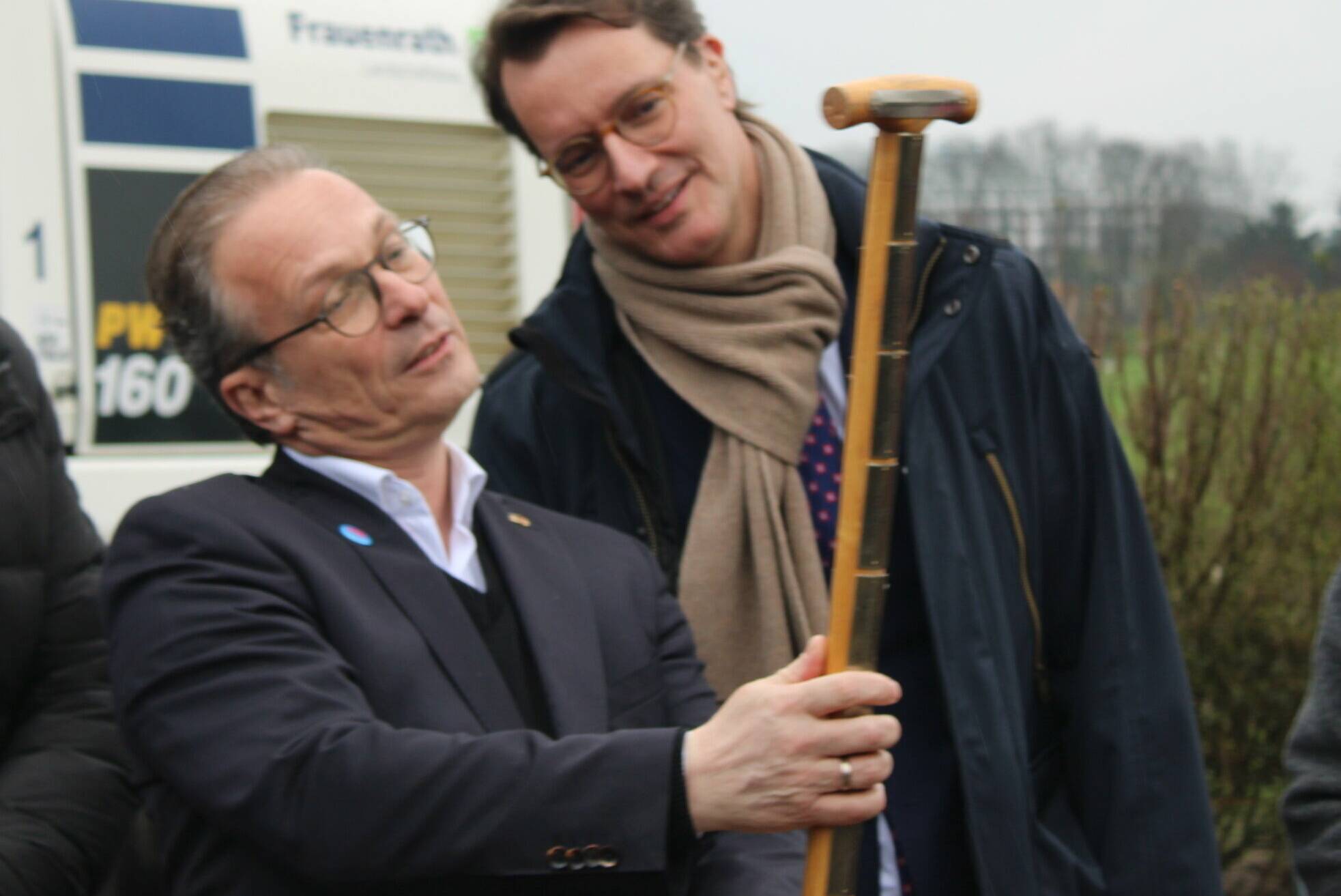 Bürgermeister Reiner Breuer zeigt Ministerpräsident Hendrik Wüst den Wanderspaten, den der Stadtchef von der Laga aus Höxter mitgebracht hatte.
