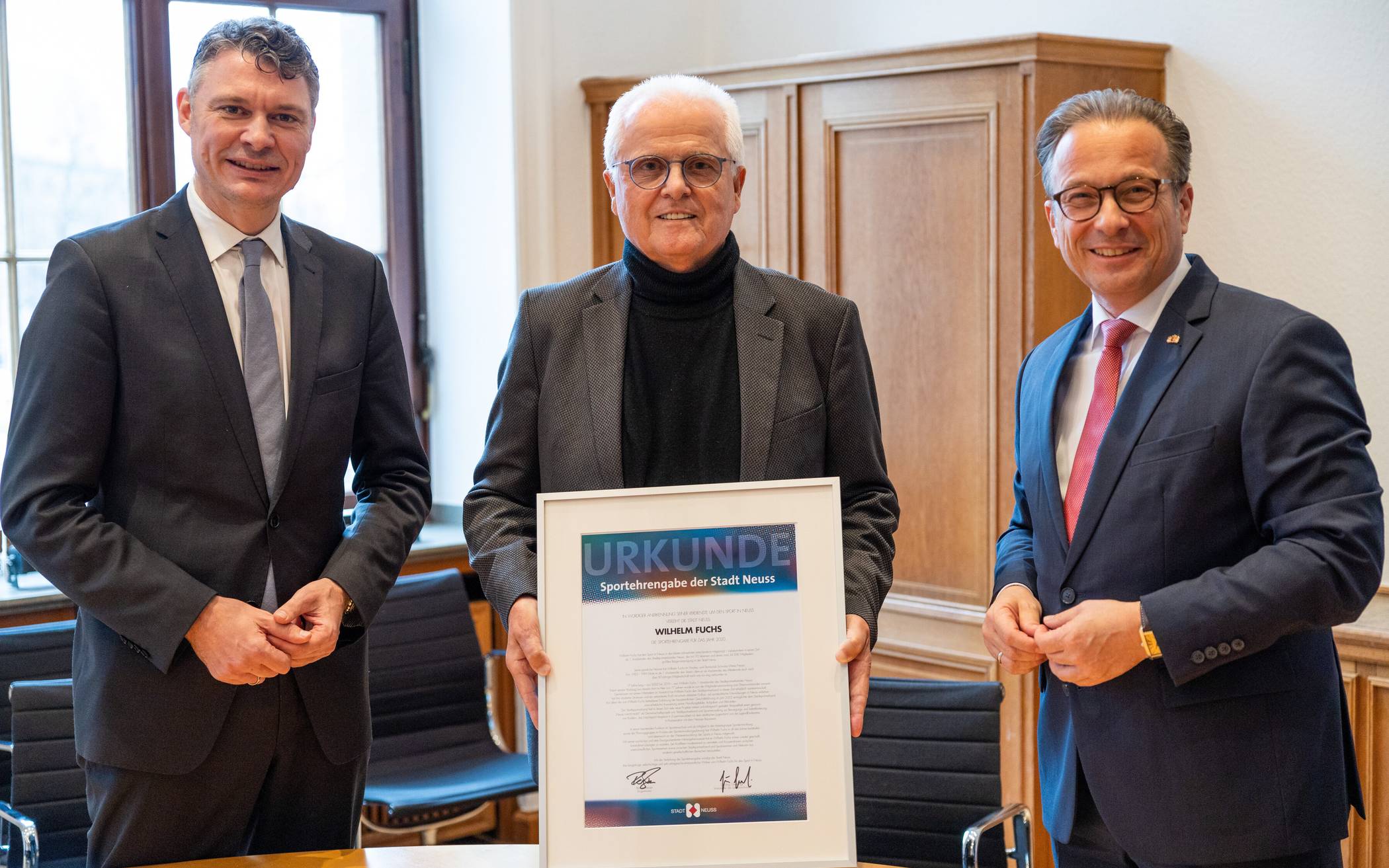  Wilhelm Fuchs (Mitte) freut sich über den Sportehrenpreis der Stadt Neuss, überreicht vom Vorsitzenden des Sportausschusses Dr. Jörg Geerlings (l.) und Bürgermeister Reiner Breuer.  
  