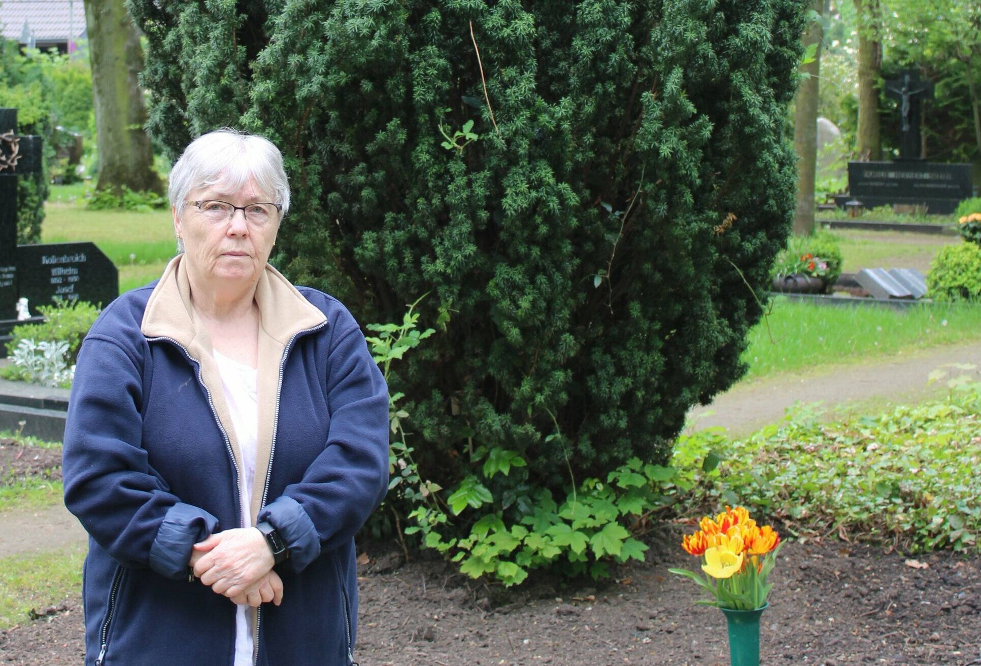  Agnes Keusen vor dem geräumten Grab ihrer Großeltern: Im Schatten des Lebensbaums will sie weiterhin regelmäßig eine Blumenvase aufstellen.  