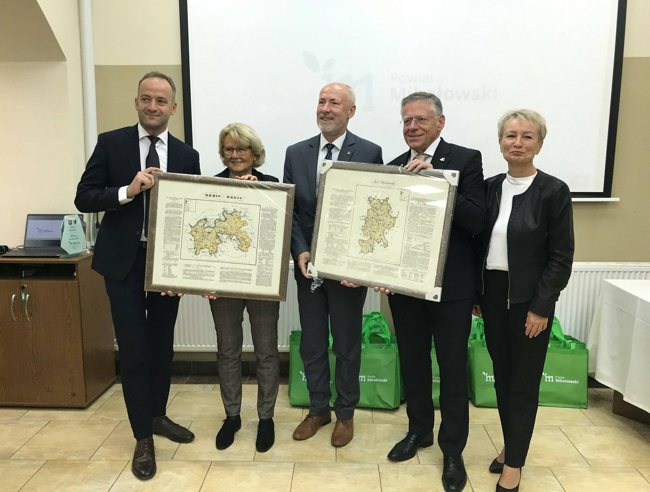 Faksimilekarten der Kreise Grevenbroich und Neuss von 1830 überreicht (von links): Jaroslaw Sworzen, stellvertretender Landrat des Kreises Mikolów, Angela Stein-Ulrich, die Vorsitzende des Partnerschaftskomitees Rhein-Kreis Neuss, die Landräte Miroslaw Duzy und Hans-Jürgen Petrauschke sowie Grazyna Nazar, Mikolóws Dezernentin für Bildung und internationale Zusammenarbeit.