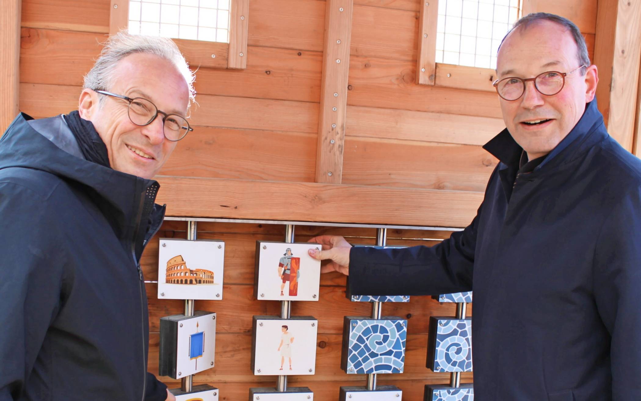 Beigeordneter Christoph Hölters (r.) und Bürgermeister Reiner Breuer probieren das Memoryspiel auf dem Römerspielplatz aus.