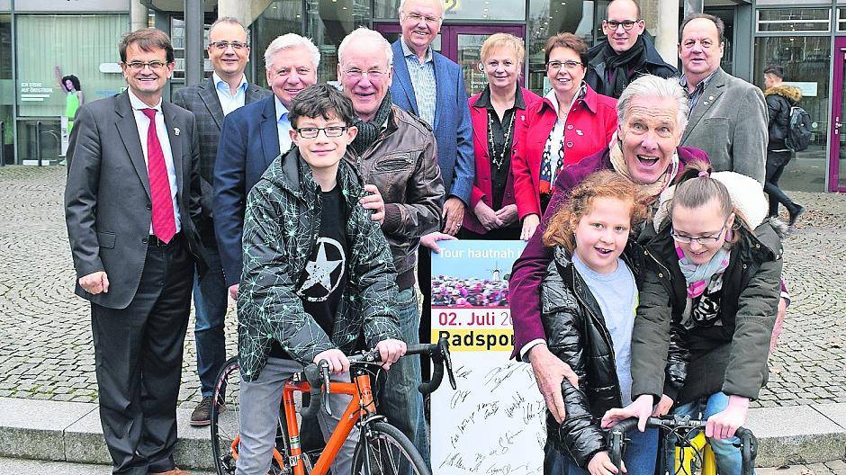  Die Büttgener Gesamtschüler Jannik (14), Dilcan (10) und Victoria (14) probieren schon mal die Fahrräder aus, die Vertreter des „Tour hautnah“-Orgateams freuen sich über den erwirtschafteten Überschuss. 