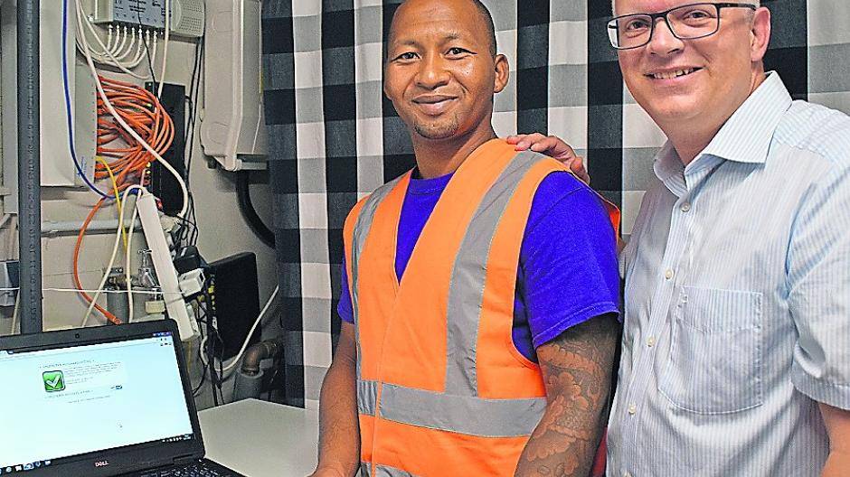  Anwohner Marcus Deuß und Glasfaser-Mitarbeiter Edburth Decaster freuen sich über den Anschluss. 