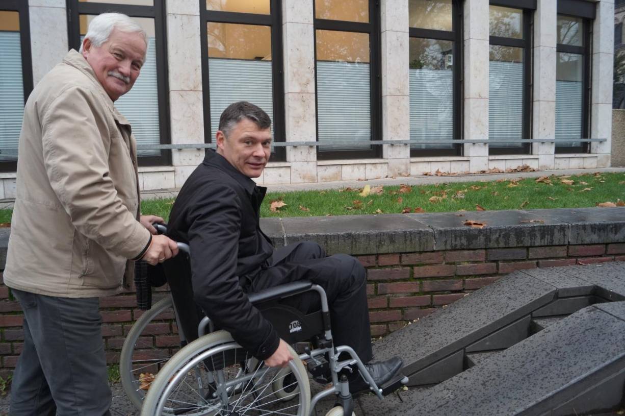  Das schafft Dr. Jörg Geerlings (CDU) nicht allein: Um mit dem Rollstuhl zum Freithof hochzufahren, braucht er die Hilfe von Max Fischer, Behindertenbeauftragter der Stadt Neuss.  