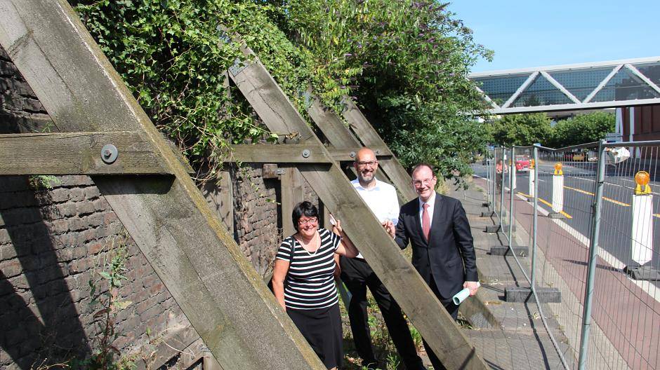  Baudezernent Christoph Hölters, Gerd Eckers, Abteilungsleiter im Tiefbaumanagement Neuss, und die Abteilungsleiterin der Unteren Bodendenkmalpflege, Sabine Sauer neben der Stützwand. 
