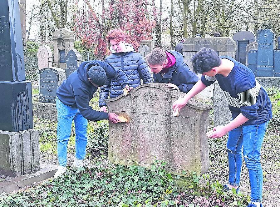 Schüler des Marie-Curie-Gymnasiums säuberten vorsichtig Grabsteine auf dem jüdischen Friedhof. <![CDATA[]]>