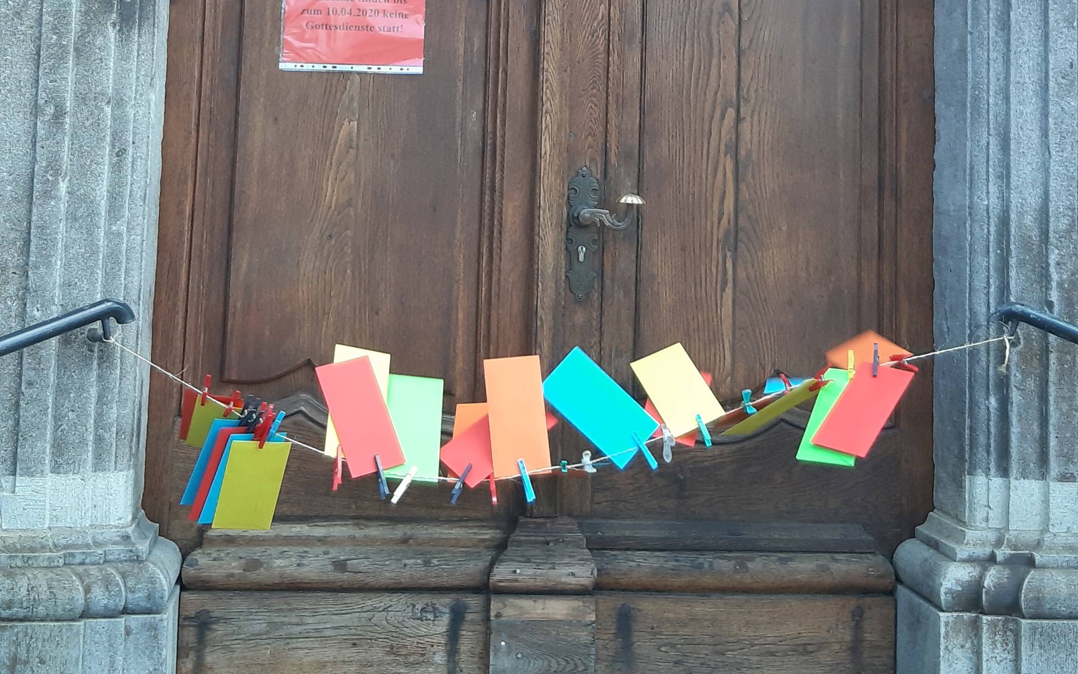 Bunte Hoffnungsbriefe hängen an der Kirchentür