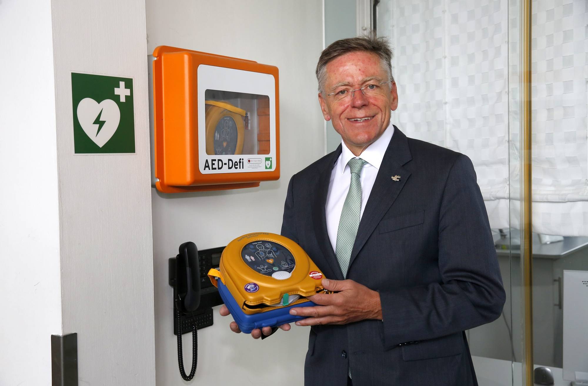  „Sinnvolle Investition in die Sicherheit unserer Kunden und Mitarbeiter“: Landrat Hans-Jürgen Petrauschke mit einem Defibrillator im Kreishaus. 