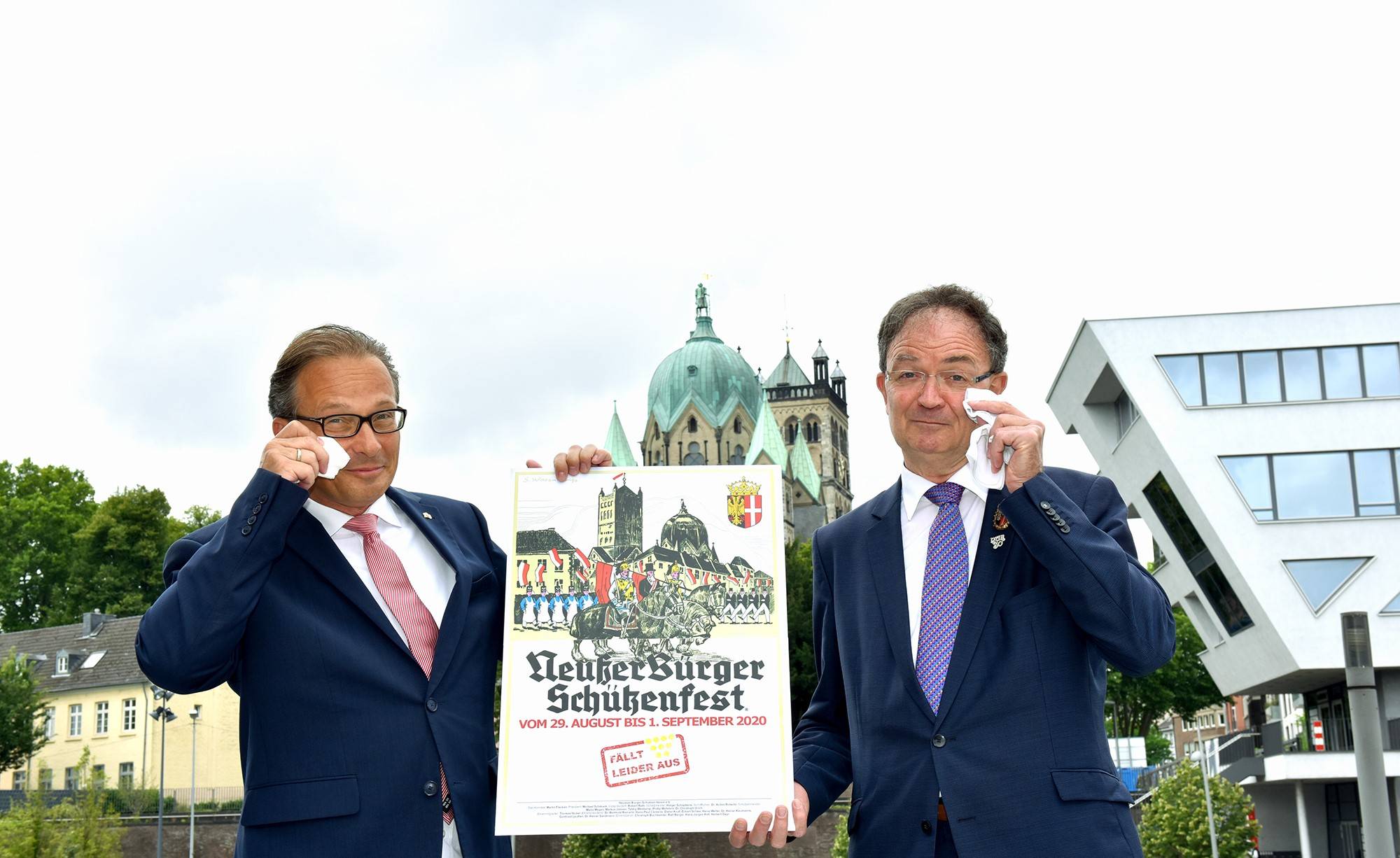  Ein Tränchen müssen sie schon – natürlich augenzwinkernd – verdrücken: Bürgermeister Reiner Breuer und Schützenpräsident Martin Flecken (v.l.) präsentieren das Schützenfestplakat 2020. das leider nicht in der Stadt verbreitet werden kann. 